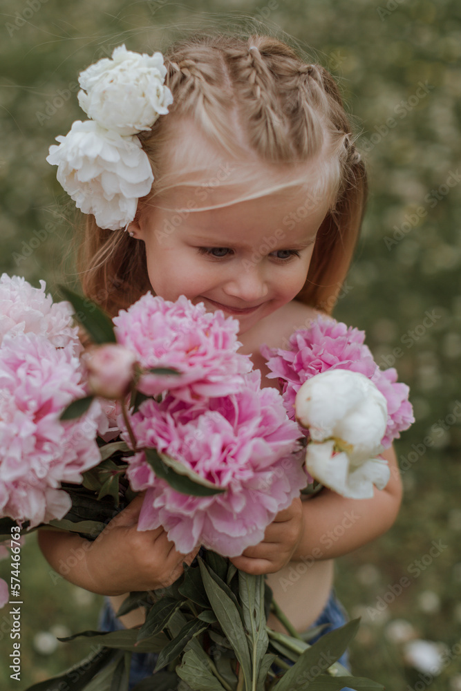 Beautiful little girl with big peonies bouquet. Spring blossom and carefree childhood concept. Beautiful little girl with big peonies bouquet. Spring blossom and carefree childhood concept.