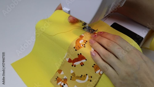 Hobby sewing on a sewing machine. The tailor cuts out the details of the product and sews. The girl is engaged in needlework, creativity.