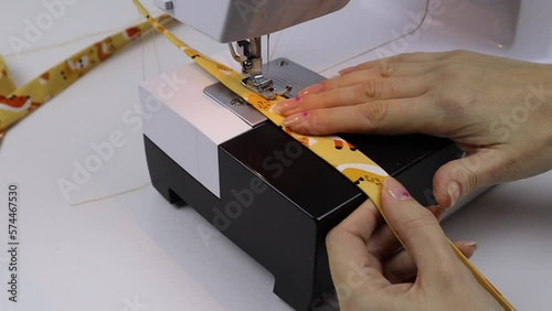 Hobby sewing on a sewing machine. The tailor cuts out the details of the product and sews. The girl is engaged in needlework, creativity.