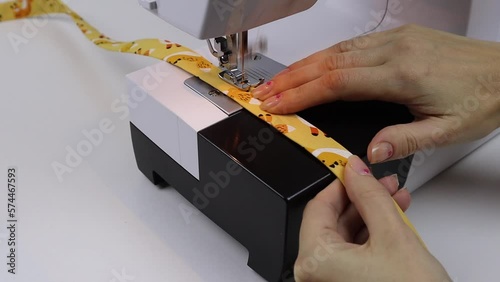 Hobby sewing on a sewing machine. The tailor cuts out the details of the product and sews. The girl is engaged in needlework, creativity.