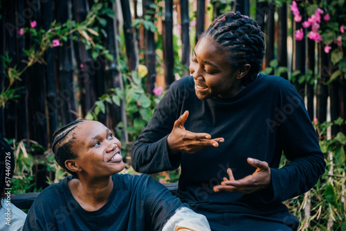 Queer masculine black women talking in a garden