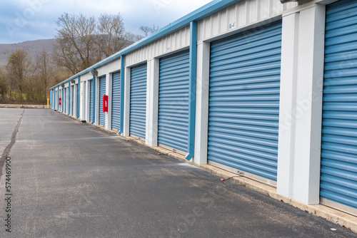 Rental storage units and climate con self storage facility with fire extinguishers mounted between the roller doors. Beautiful exterior view with a mountain background located near Huntsville Alabama.