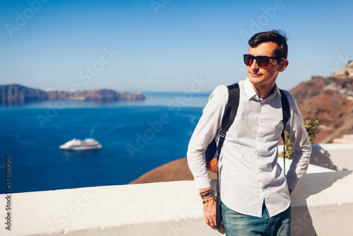 Santorini traveler man enjoying Fira or Thera town landscapes, Greece. Tourism, traveling, summer vacation