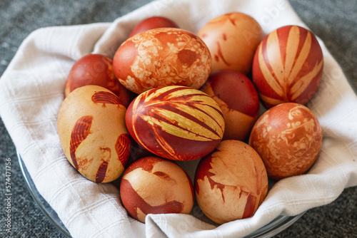 Una cesta fai da te di uova di Pasqua decorate, decorazioni pasquali in ambiente casalingo e luminoso photo