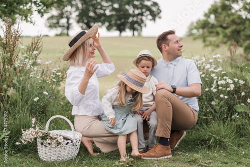 A Happy family on daisy field at the sunset having great time together
