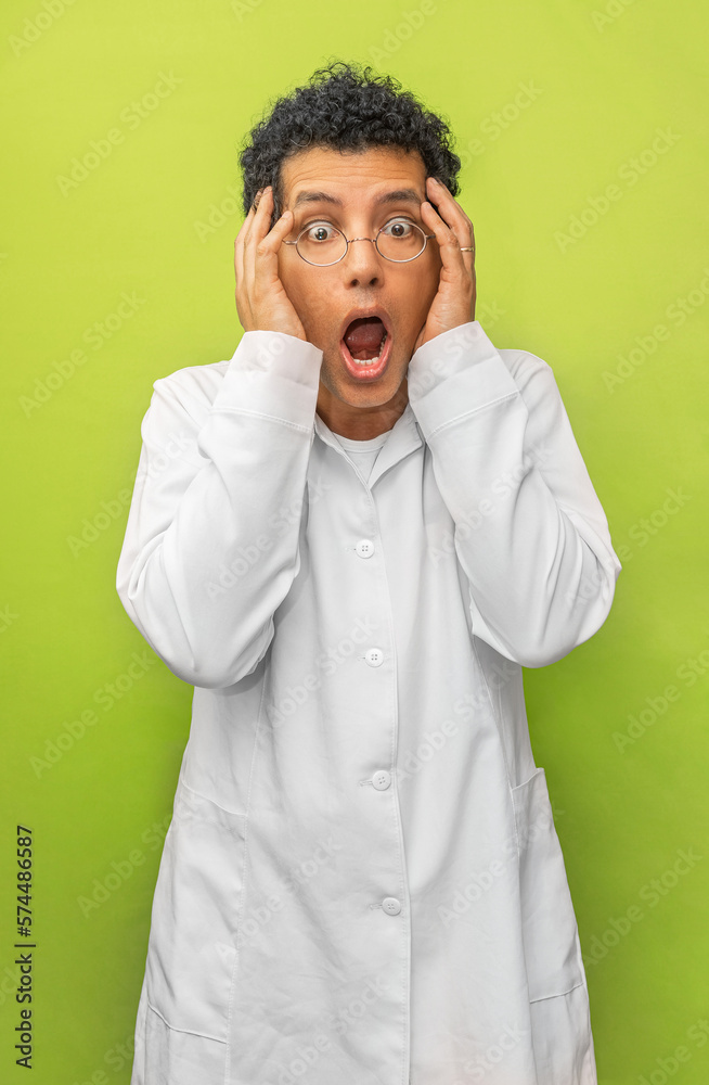 Portrait of a genius scientist happy with his science experiment on a green background. Medical doctor with white coat Portrait of a genius scientist happy with his science experiment on a green background. Medical doctor with white coat