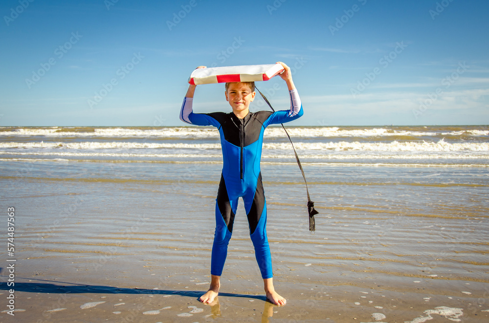 Young Preteen Boy Standing in Rash Suit on the Beach Holding A Boogie