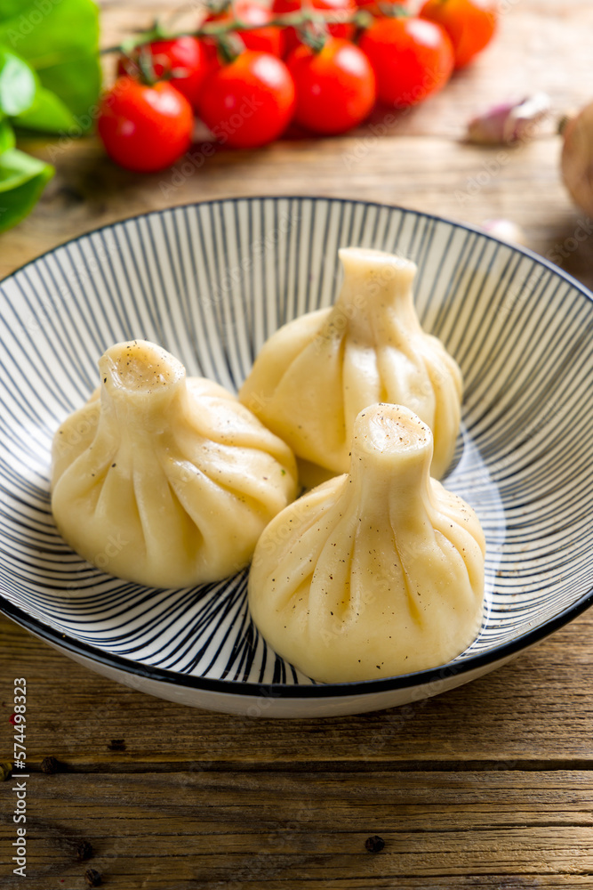 Khinkali with lamb on plate on wooden table vertical