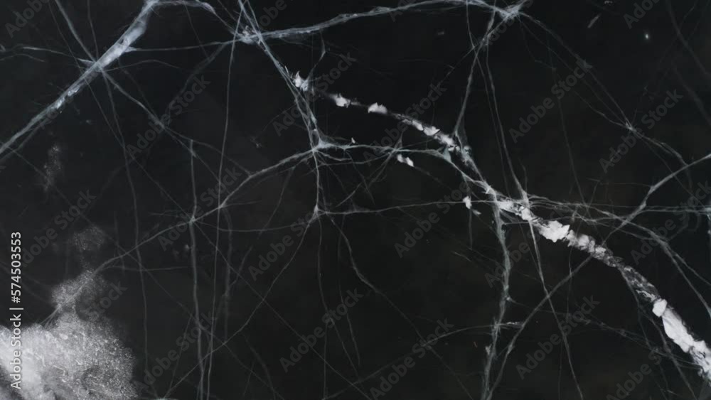 White icy veins in surface of dark frozen lake, top down White icy veins in surface of dark frozen lake, top down