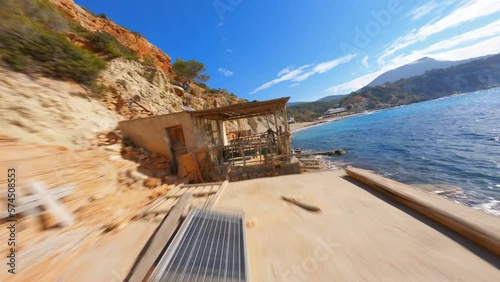 Epic FPV aerial flying through a boathouse patio along the scenic coast of Spain. photo