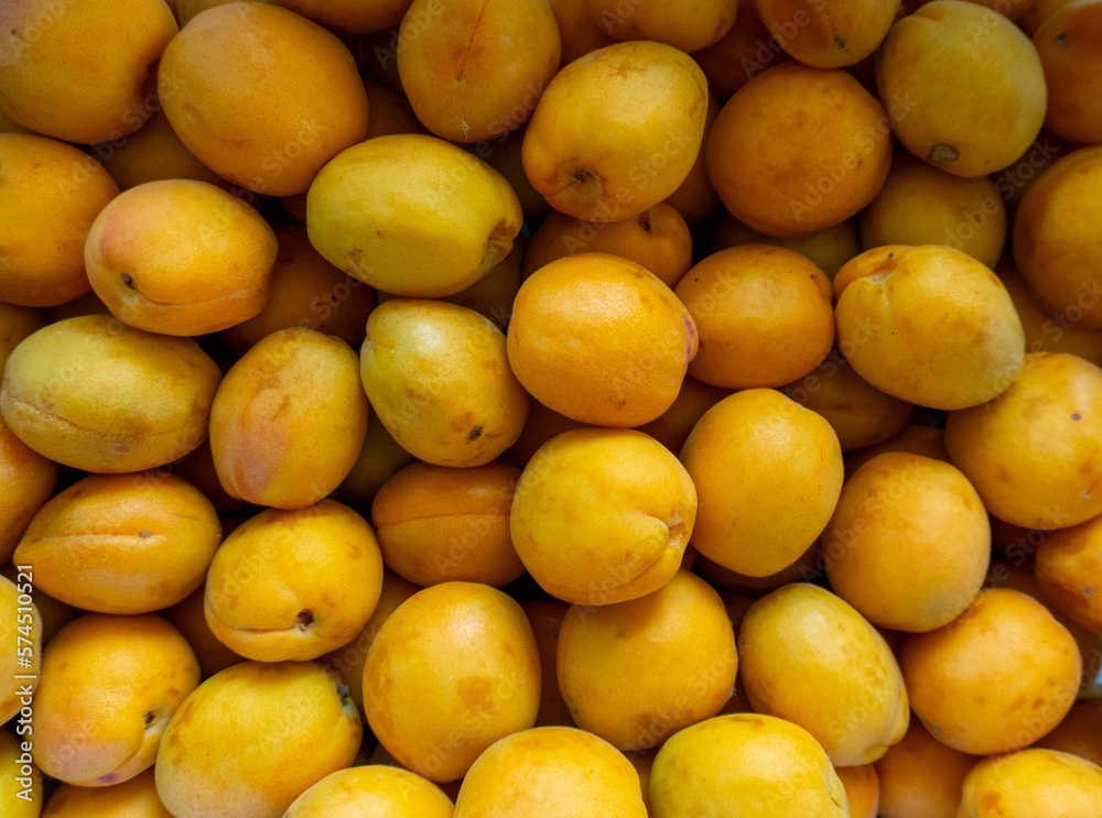 photo of a lot of apricots on the counter of the store
