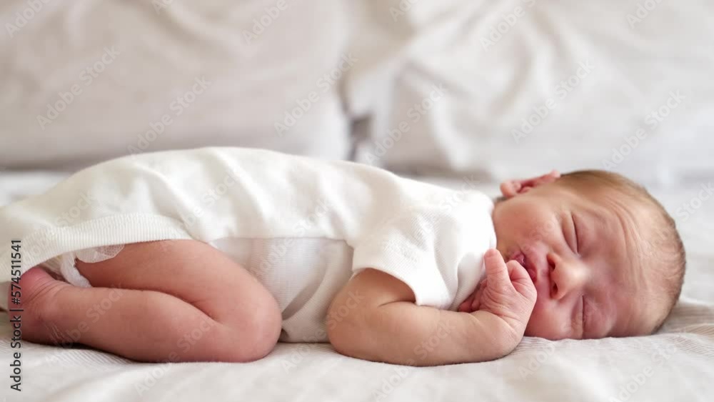 Cute adorable newborn baby boy lying on stomach, frowning,screwing face on white bed at home sleeping,Purity,innosence concept.Full body shot. Cute adorable newborn baby boy lying on stomach, frowning,screwing face on white bed at home sleeping,Purity,innosence concept.Full body shot.