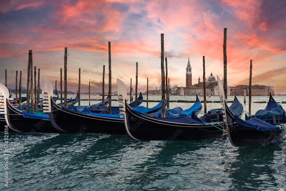 Gondolas moored in grand canal,
with San Giorgio di Maggiore church at sunset in Venice, Italy - Travel concept
