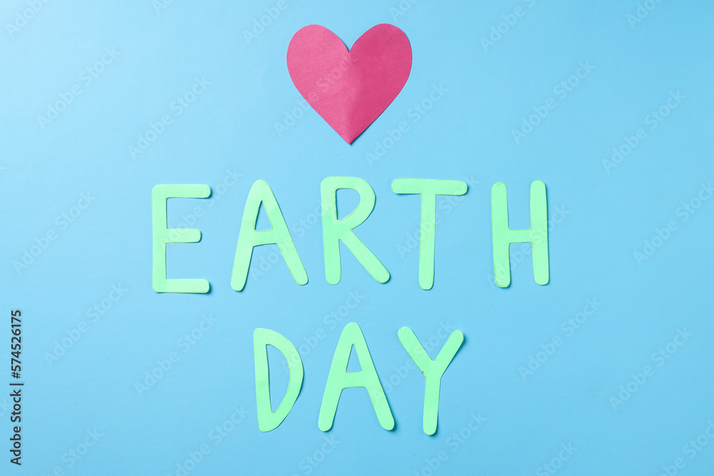 Top view of red heart shape with earth day lettering isolated on blue background. World earth day concept. 