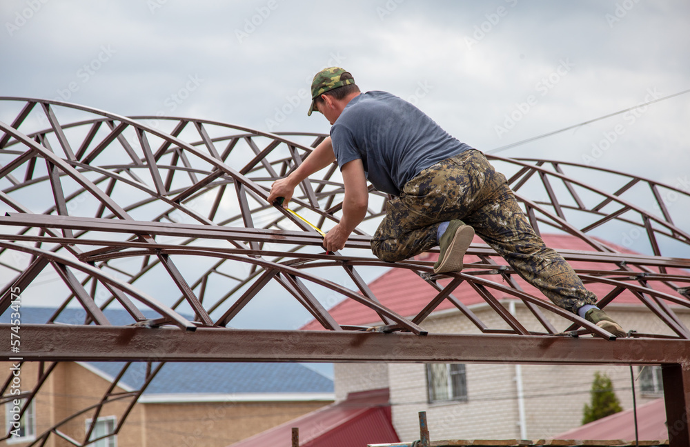 The worker installs the metal on the canopy. The worker installs the metal on the canopy.