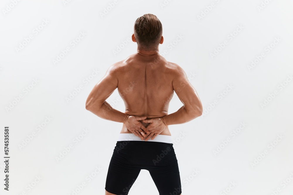 Man athletic body bodybuilder in briefs with naked torso abs full-length in the background, fitness classes. Advertising, sports, active lifestyle, competition, challenge concept.