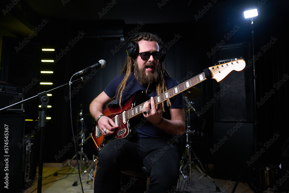 Fototapeta premium Guitarist man plays an electric guitar Close-up at studio