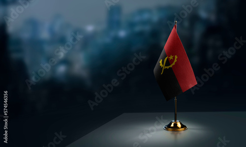 Billede på lærred A small Angola flag on an abstract blurry background