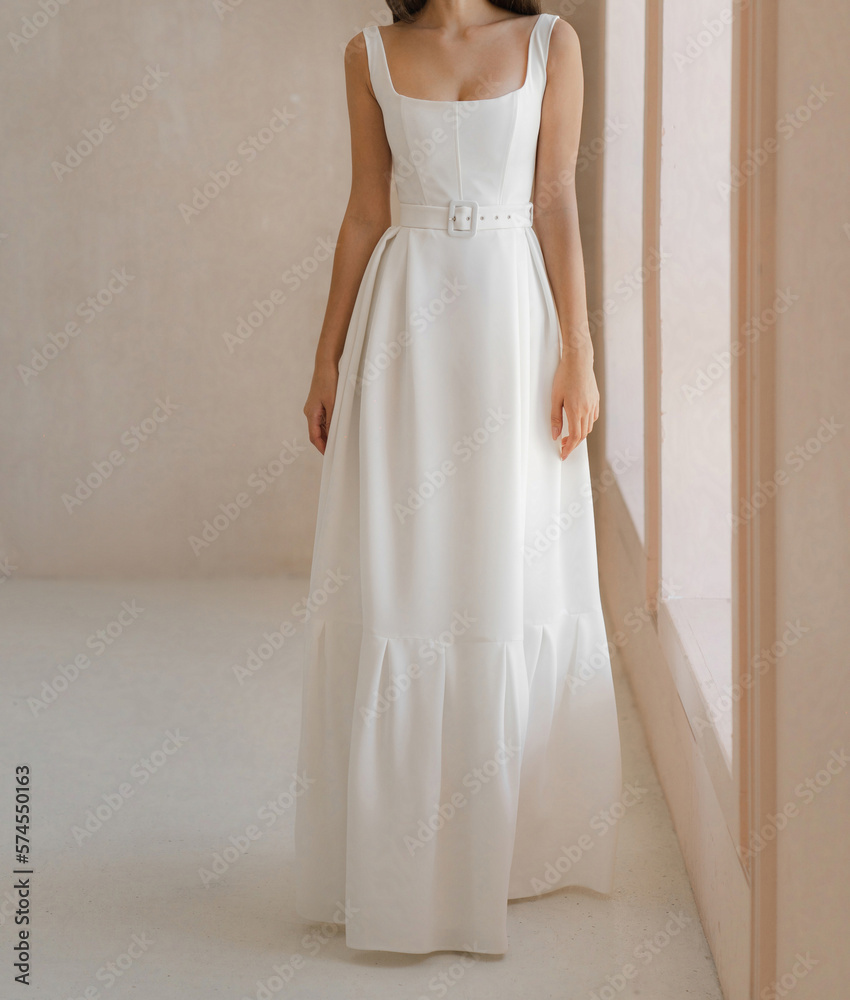 Beautiful bride in the white long wedding dress. Classic sleeveless wedding dress with deep neckline and belt. Beautiful bride in the white long wedding dress. Classic sleeveless wedding dress with deep neckline and belt.