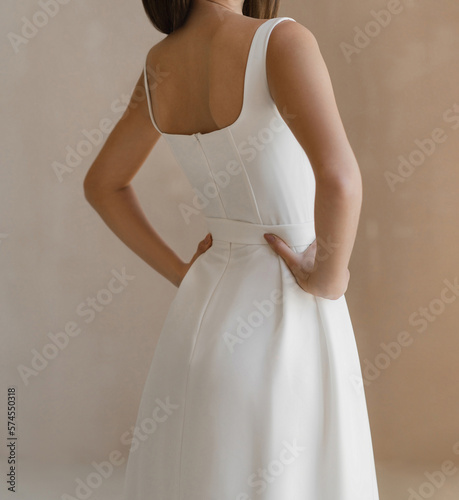 Beautiful bride with naked back dressed in a white wedding dress. Gorgeous wedding sleeveless dress.