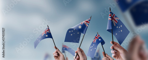 A group of people holding small flags of the Australia in their hands photo