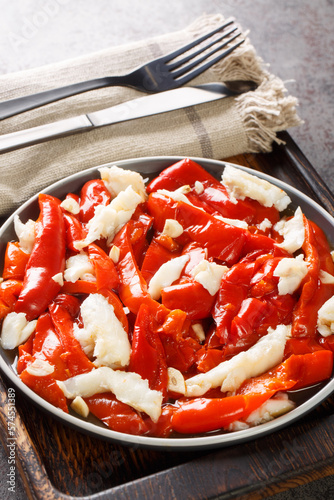 Esgarraet valenciano or esgarrat is a typical dish of Spanish cuisine made of cod fish, bell peppers and garlic closeup on the plate on the table. Vertical photo