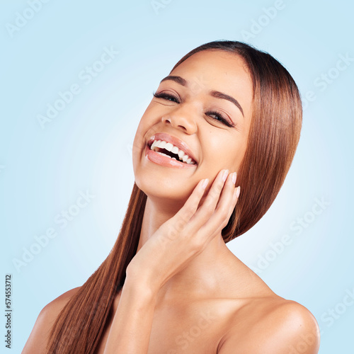Portrait, beauty and hair with a black woman in studio on a blue background for natural haircare. Face, skincare and keratin with an attractive young female model feeling proud of her hairstyle