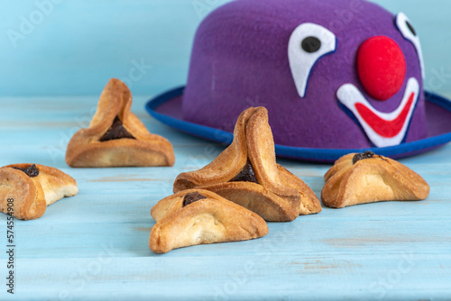 Traditional cookies Hamantaschen for Jewish holiday Purim on the background of carnival decoration.