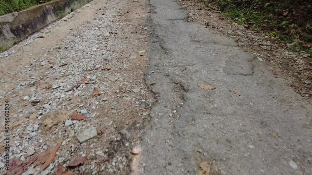 Slow hike up the hill through broken asphalt road. A man walk down the hill Slow hike up the hill through broken asphalt road. A man walk down the hill