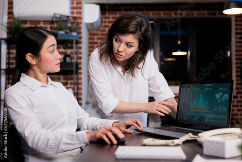 Executive board members reviewing wrongly issued accounting data on laptop screen. Multiracial marketing company employees in office workspace analyzing financial charts and graphs.