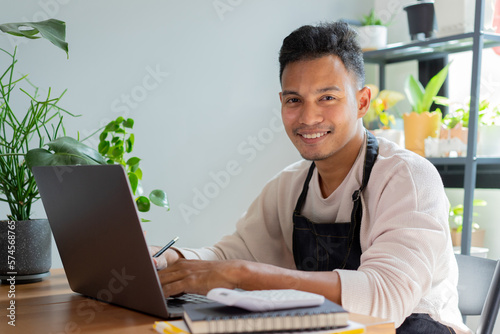 close up young business owner of plant shop arm crossed while sit in the room to research about economic and marketing for startup and business lifestyle concept