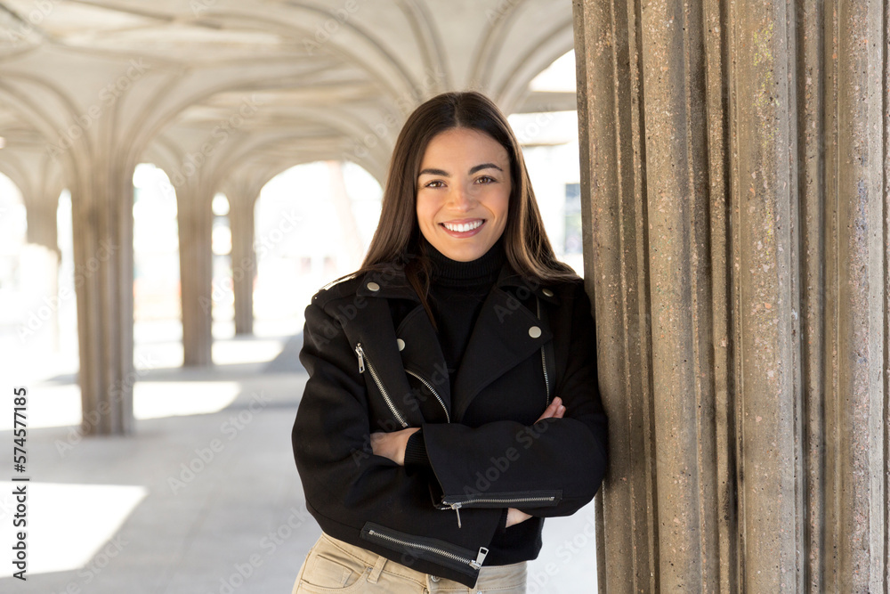 Cool woman smiling at camera standing with arms crossed outdoors Cool woman smiling at camera standing with arms crossed outdoors