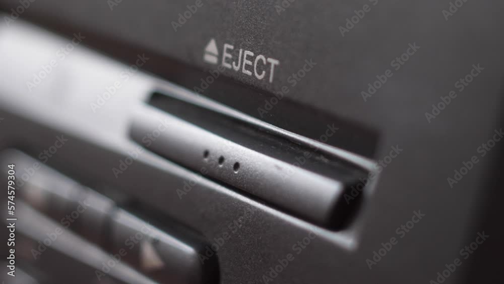extreme close-up Pressing the button on the panel of the VCR with your finger ejects the video cassette. Videocassette player close eject buttons.Selective focus extreme close-up Pressing the button on the panel of the VCR with your finger ejects the video cassette. Videocassette player close eject buttons.Selective focus