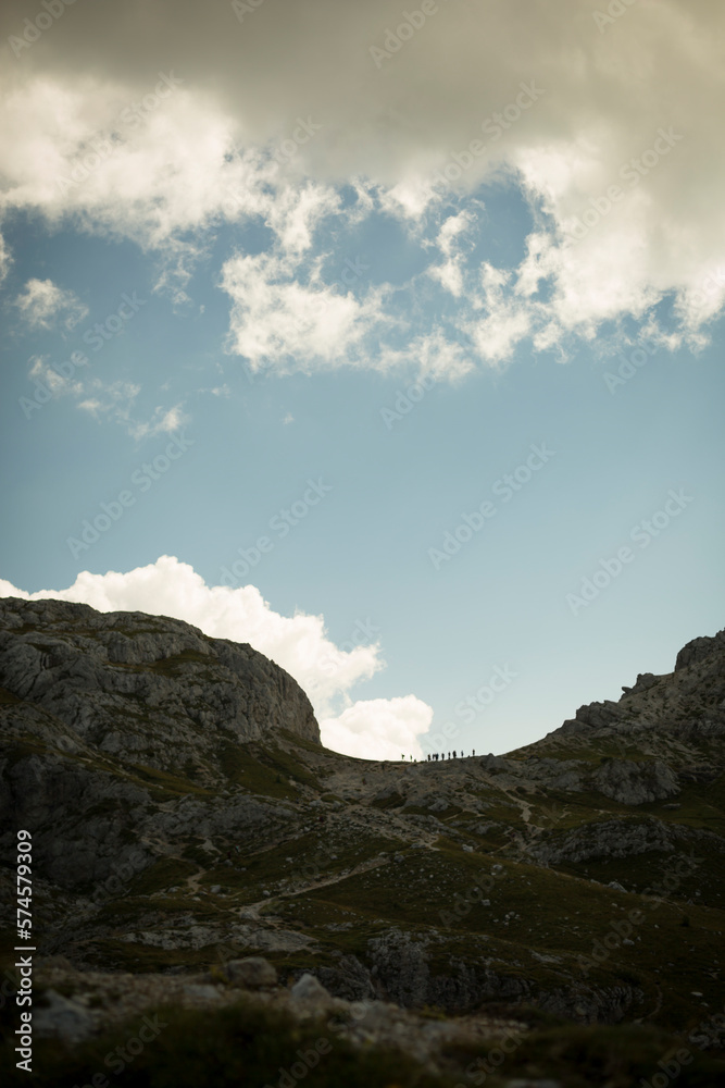 The silhouettes of hikers outline on a blue sky in Italy's Dolomite Region. The silhouettes of hikers outline on a blue sky in Italy's Dolomite Region.