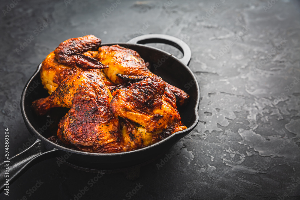 Roasted half chicken in pan on black background Roasted half chicken in pan on black background