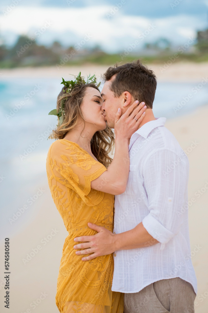 Portrait of couple kissing on beach by ocean Portrait of couple kissing on beach by ocean