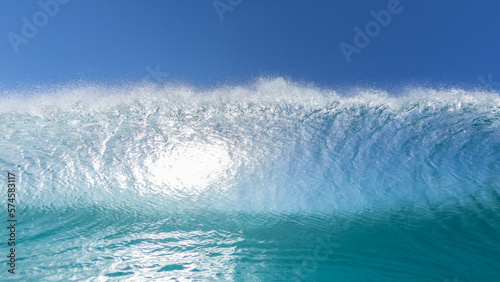 Wave Ocean Swimming Close Up Face To Face Encounter Blue Water Wall Crashing with Backlit Blue Sky.