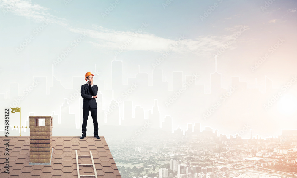Engineer man standing on roof and looking away. Mixed media Engineer man standing on roof and looking away. Mixed media