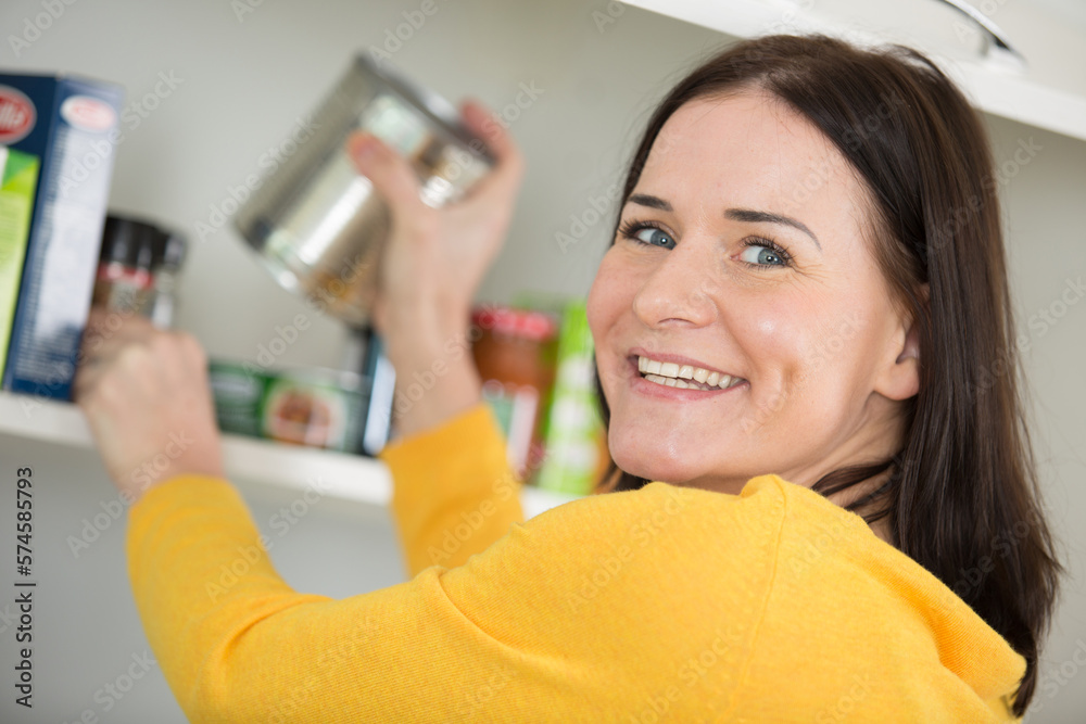 happy woman looking in empty food cupboards happy woman looking in empty food cupboards