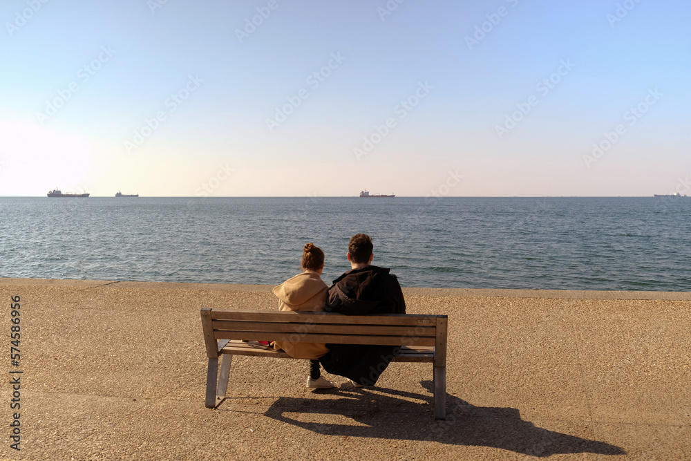 couple sitting on a bench by the sea
