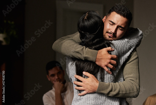 Hug, support and crying man embrace for comfort, grief and care after bad news or problems in a home or house. Cancer, sad and depression by people hugging for empathy, love and hope together photo
