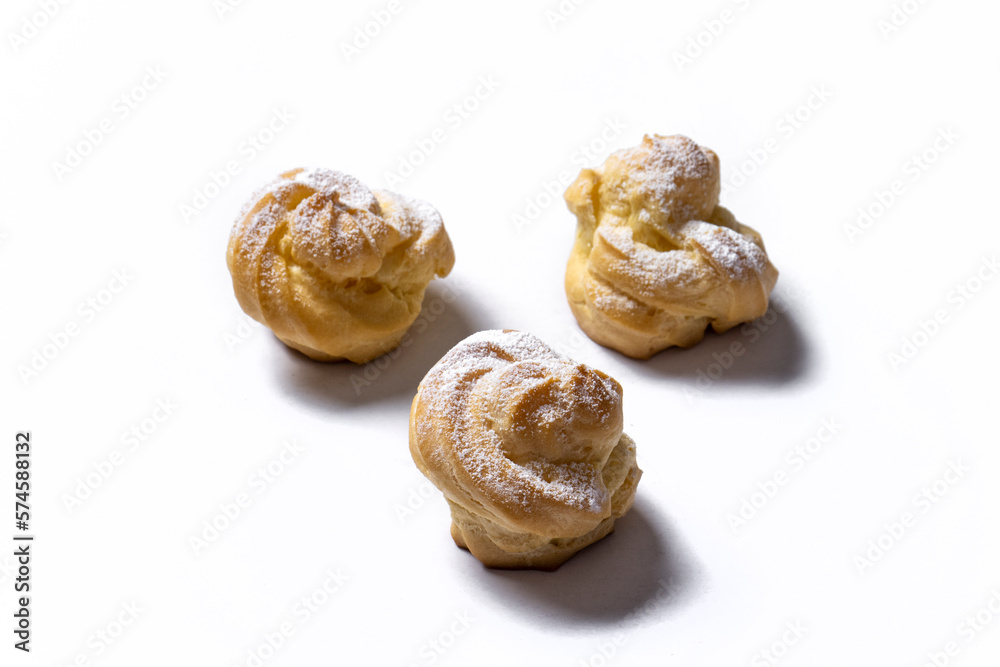 Decorating profiteroles with powdered sugar. Eclairs with icing sugar