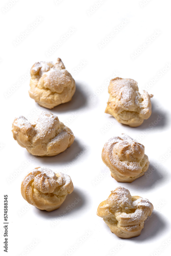 Decorating profiteroles with powdered sugar. Eclairs with icing sugar