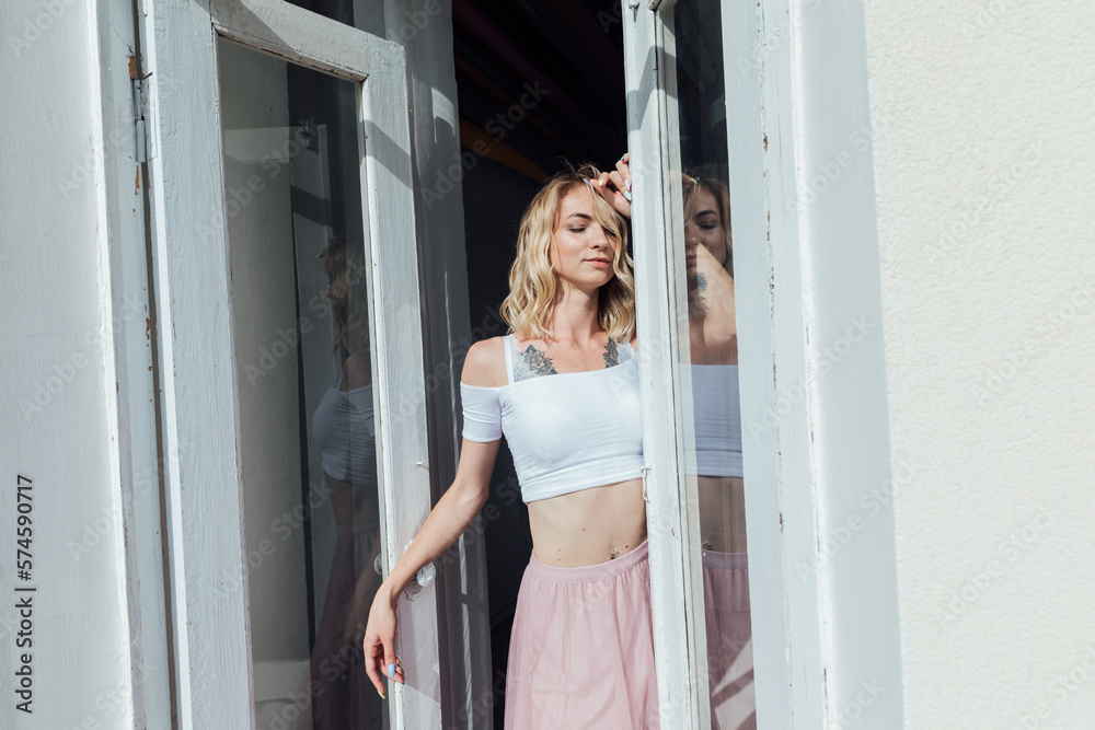 a woman in a pink skirt stands at the door in the room a woman in a pink skirt stands at the door in the room