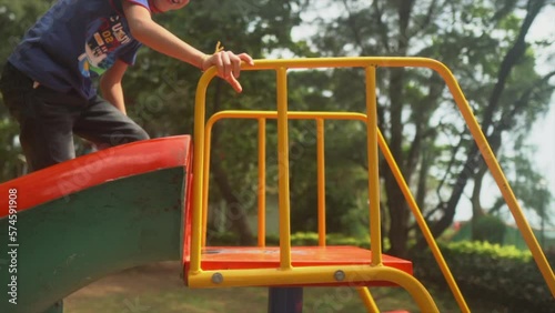 happy child in the playground climbing the colourful slide and then sliding. photo