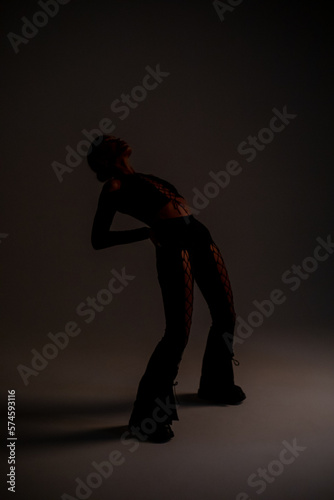 Stylish woman in a sexy black suit with lacing. Fashion photoshoot. © kanashkin