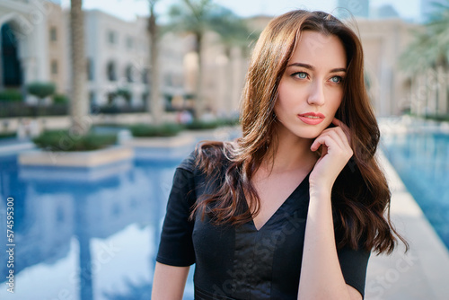 Close-up portrait of beautiful caucasian woman with charming smile and long hair walking on the Dubai street.