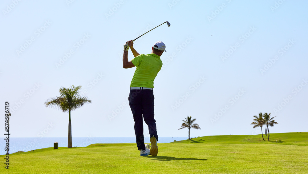 Golfer on a golf course, ready to tee off. Golfer with golf club hitting the ball for the perfect shot.