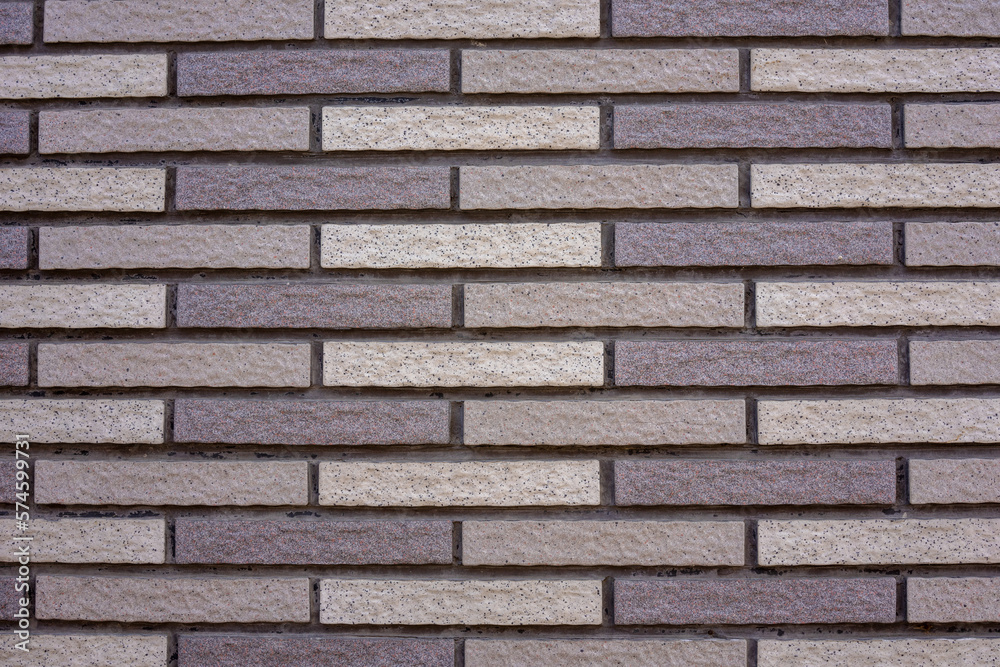 Texture of narrow clean beige gray bricks. Background of a modern house wall. Texture of narrow clean beige gray bricks. Background of a modern house wall.