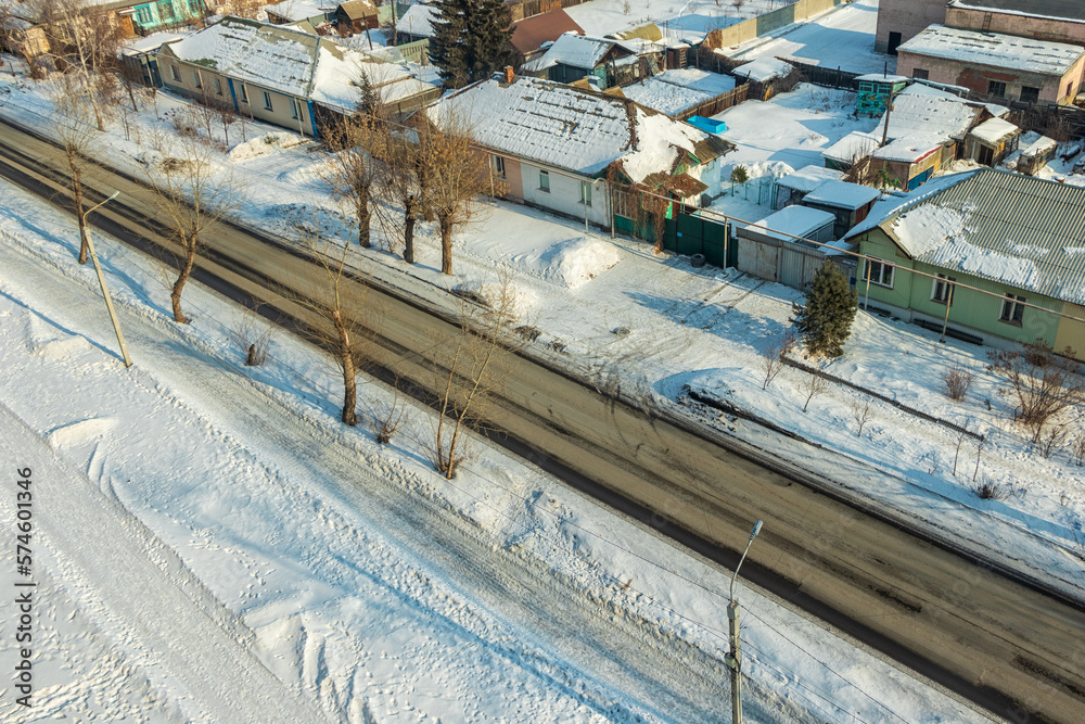 Top view of the road and nearby houses on a winter day.